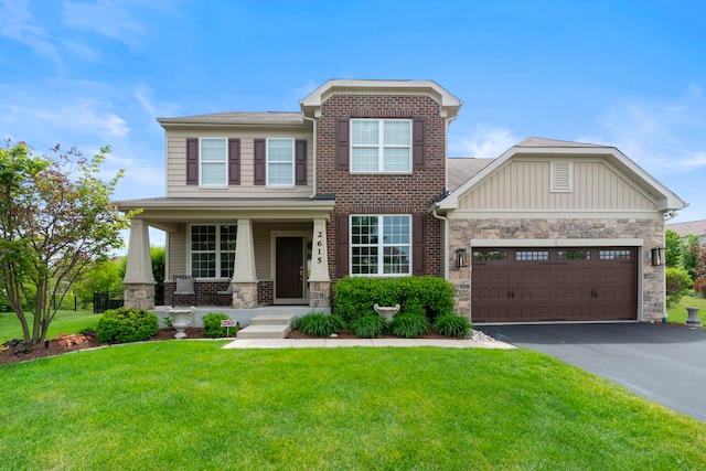 2615 Camden St, Geneva, IL 60134 - view of front of house with driveway, an attached garage, a front lawn, stone siding, and a porch