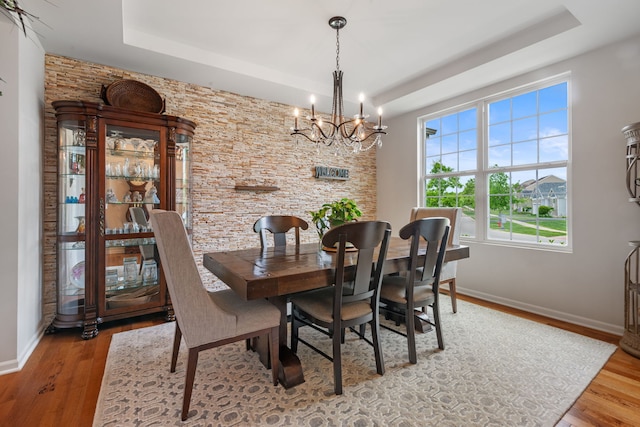 2615 Camden St, Geneva, IL 60134 - dining area featuring a tray ceiling, a chandelier, baseboards, and wood finished floors