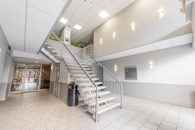 7234 W N Ave Unit 1902, Elmwood Park, IL 60707 - staircase with a high ceiling, a drop ceiling, baseboards, and tile patterned floors
