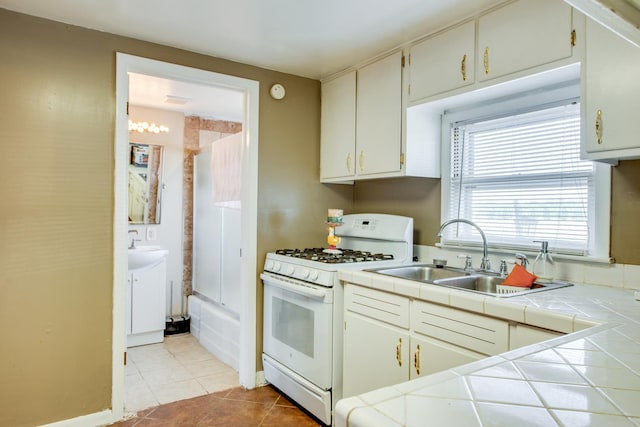 2105 Caton Farm Rd, Crest Hill, IL 60403 - kitchen with white gas range, tile counters, and light tile patterned flooring