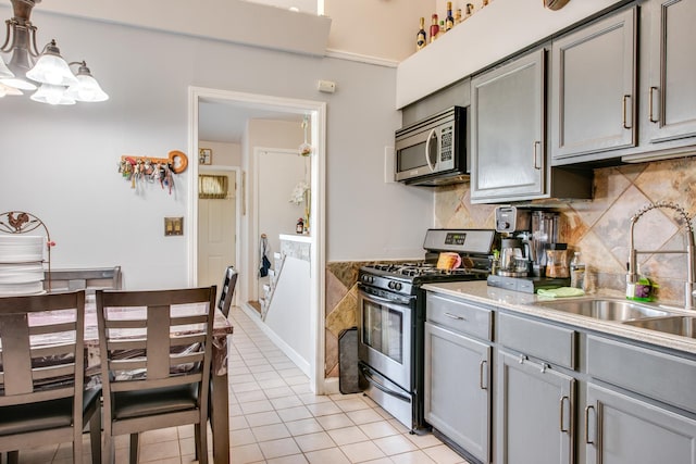 2105 Caton Farm Rd, Crest Hill, IL 60403 - kitchen with stainless steel appliances, gray cabinetry, tasteful backsplash, a chandelier, and light tile patterned floors