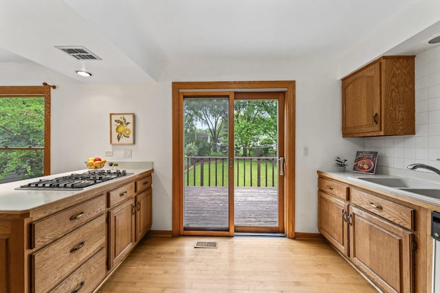 169 S Ellyn Ave, Glen Ellyn, IL 60137 - kitchen with stainless steel gas stovetop, brown cabinets, light wood-type flooring, light countertops, and a peninsula