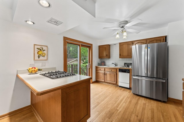 169 S Ellyn Ave, Glen Ellyn, IL 60137 - kitchen featuring appliances with stainless steel finishes, light countertops, light wood-style floors, and a peninsula