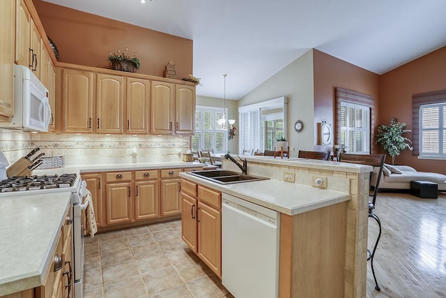 608 Bridgeman Ln, Romeoville, IL 60446 - kitchen with white appliances, a sink, lofted ceiling, a kitchen breakfast bar, and light brown cabinetry