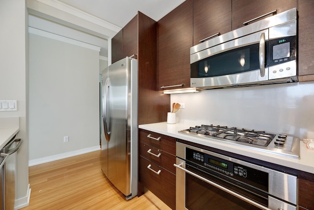 1570 Elmwood Ave Unit 910, Evanston, IL 60201 - kitchen featuring stainless steel appliances, dark brown cabinetry, light wood-type flooring, light countertops, and baseboards