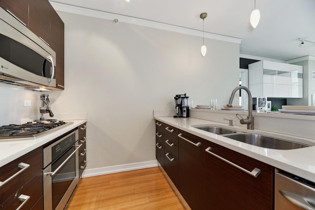 1570 Elmwood Ave Unit 910, Evanston, IL 60201 - kitchen with stainless steel appliances, a sink, crown molding, light wood-style floors, and light countertops