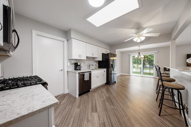17828 Massachusetts Ct, Orland Park, IL 60467 - kitchen with dishwasher, fridge with ice dispenser, black microwave, a ceiling fan, and light wood-type flooring