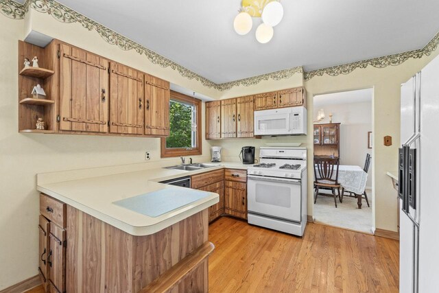 137 N Clark Dr, Palatine, IL 60074 - kitchen with white appliances, a peninsula, light countertops, a sink, and light wood-style floors