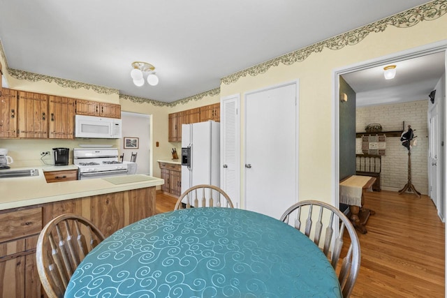 137 N Clark Dr, Palatine, IL 60074 - kitchen with white appliances, wood finished floors, brown cabinetry, light countertops, and a sink