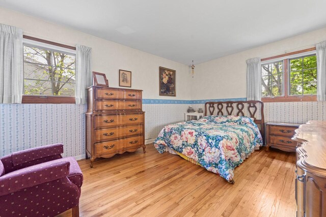 137 N Clark Dr, Palatine, IL 60074 - bedroom with wallpapered walls, light wood-style flooring, a wainscoted wall, and multiple windows
