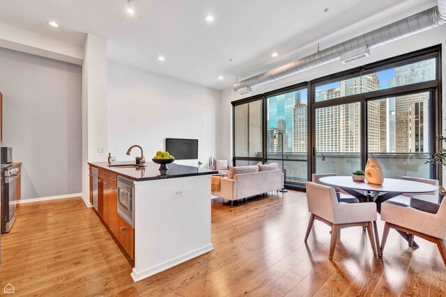240 E Illinois St Unit 805, Chicago, IL 60611 - kitchen featuring stainless steel microwave, light wood-style flooring, a peninsula, recessed lighting, and a sink