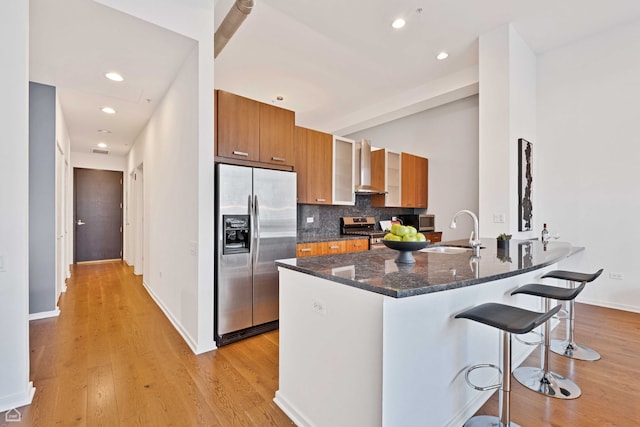 240 E Illinois St Unit 805, Chicago, IL 60611 - kitchen featuring appliances with stainless steel finishes, a sink, brown cabinets, a breakfast bar area, and light wood-style flooring