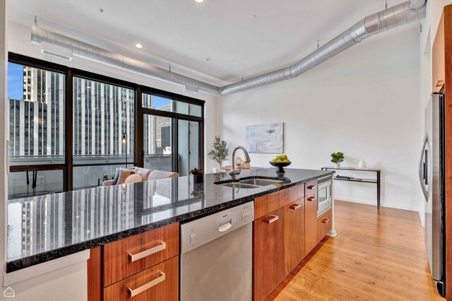 240 E Illinois St Unit 805, Chicago, IL 60611 - kitchen featuring stainless steel appliances, a sink, brown cabinets, light wood-type flooring, and dark stone counters