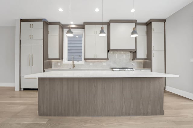 2353 W Ohio St, Chicago, IL 60612 - kitchen featuring a large island, baseboards, light countertops, backsplash, and light wood-style floors