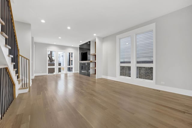 2353 W Ohio St, Chicago, IL 60612 - unfurnished living room with light wood finished floors, stairs, baseboards, and recessed lighting