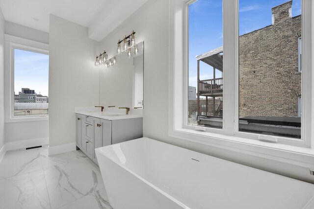 2353 W Ohio St, Chicago, IL 60612 - bathroom with a soaking tub, double vanity, marble finish flooring, and baseboards