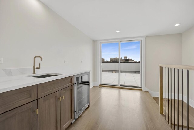 2353 W Ohio St, Chicago, IL 60612 - kitchen with a sink, beverage cooler, light wood finished floors, baseboards, and light countertops