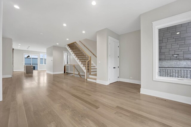 2353 W Ohio St, Chicago, IL 60612 - unfurnished living room with stairs, wood finished floors, baseboards, and recessed lighting