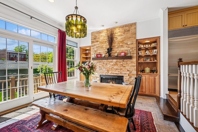 1448 N Mohawk St, Chicago, IL 60610 - dining room featuring built in shelves, crown molding, a stone fireplace, a chandelier, and recessed lighting