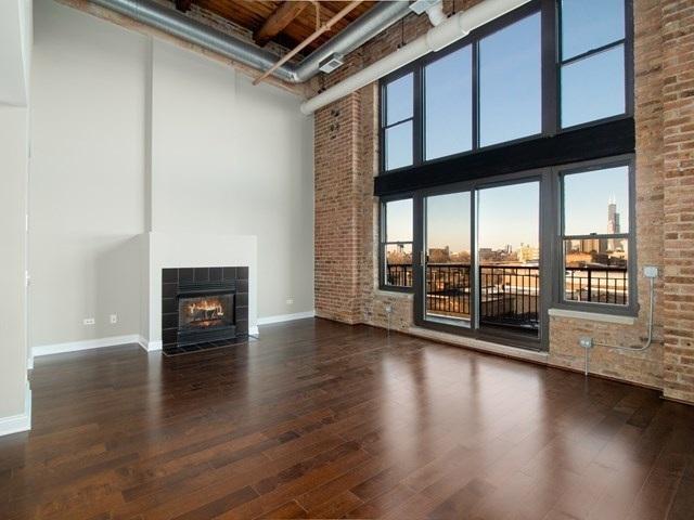 50 E 26th St Unit 406, Chicago, IL 60616 - unfurnished living room with a towering ceiling, baseboards, wood finished floors, a fireplace, and plenty of natural light