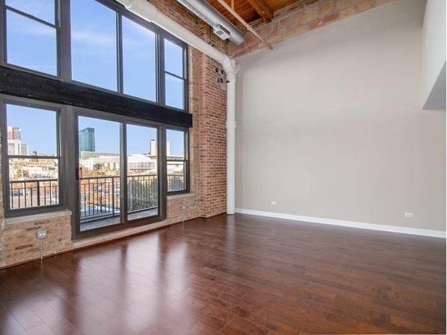 50 E 26th St Unit 406, Chicago, IL 60616 - unfurnished room with baseboards, wood finished floors, and a towering ceiling