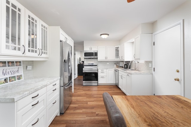 206-208 N Fremont St, Naperville, IL 60540 - kitchen featuring appliances with stainless steel finishes, a sink, decorative backsplash, light wood-style flooring, and light countertops