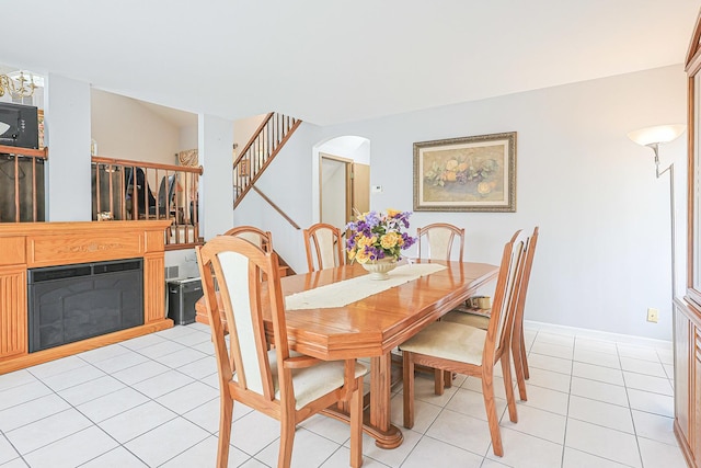 15 Brittany Ct, South Elgin, IL 60177 - dining space featuring stairs, arched walkways, light tile patterned floors, baseboards, and a glass covered fireplace