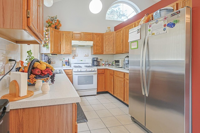 15 Brittany Ct, South Elgin, IL 60177 - kitchen with freestanding refrigerator, under cabinet range hood, white range with gas cooktop, light countertops, and light tile patterned floors