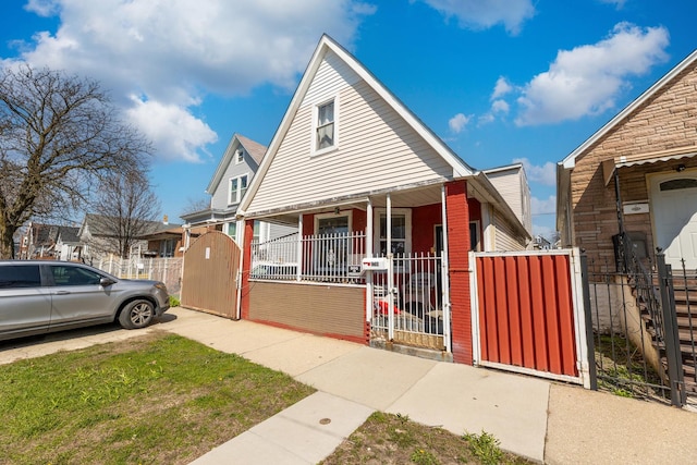 2248 W 50th Pl, Chicago, IL 60609 - bungalow-style house with a porch, a gate, a fenced front yard, and brick siding