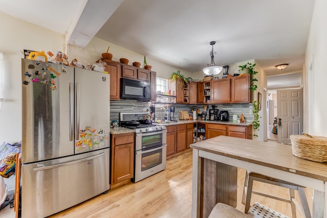 2248 W 50th Pl, Chicago, IL 60609 - kitchen with stainless steel appliances, brown cabinetry, light countertops, and tasteful backsplash