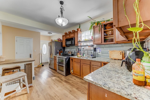 2248 W 50th Pl, Chicago, IL 60609 - kitchen featuring appliances with stainless steel finishes, brown cabinetry, decorative backsplash, a sink, and pendant lighting
