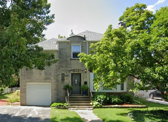 1607 183rd St, Homewood, IL 60430 - view of front facade with an attached garage, driveway, roof with shingles, stone siding, and a front yard