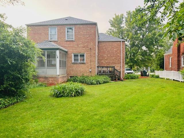 1607 183rd St, Homewood, IL 60430 - back of house featuring a yard, brick siding, a shingled roof, and a sunroom