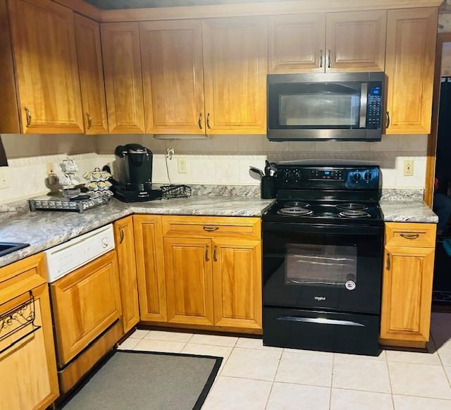 1607 183rd St, Homewood, IL 60430 - kitchen featuring stainless steel microwave, black electric range oven, dishwasher, and light tile patterned flooring