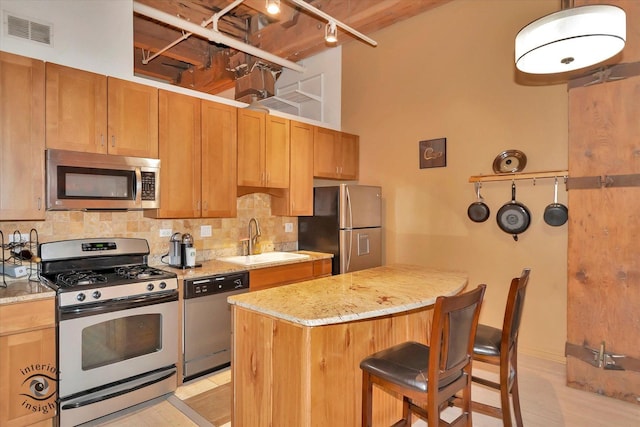 360 W Illinois St Unit 114, Chicago, IL 60654 - kitchen with stainless steel appliances, a sink, backsplash, and a kitchen island