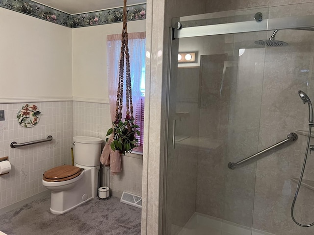 204 Elm St, Morrison, IL 61270 - bathroom featuring toilet, a shower stall, tile walls, and wainscoting