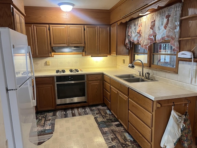 204 Elm St, Morrison, IL 61270 - kitchen with white appliances, a sink, under cabinet range hood, light countertops, and backsplash