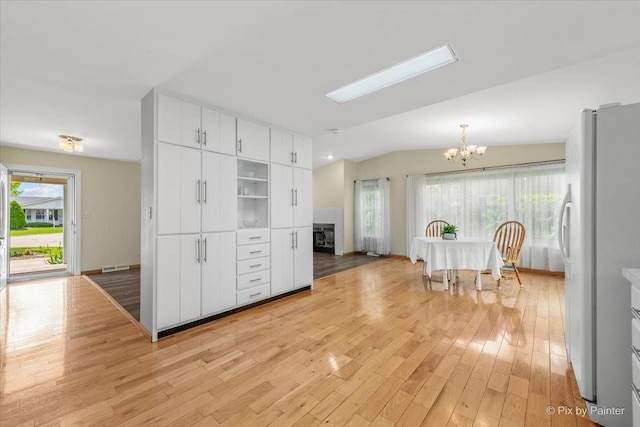 14 Devonshire Ct, Grayslake, IL 60030 - kitchen featuring freestanding refrigerator, a chandelier, plenty of natural light, light wood-type flooring, and lofted ceiling