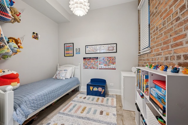 1423 N Ashland Ave Unit 201, Chicago, IL 60622 - bedroom with wood finished floors, brick wall, and baseboards