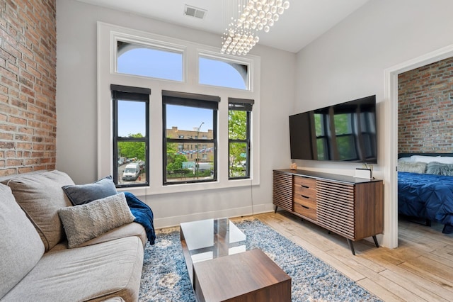 1423 N Ashland Ave Unit 201, Chicago, IL 60622 - living room with light wood-style floors, a chandelier, and brick wall