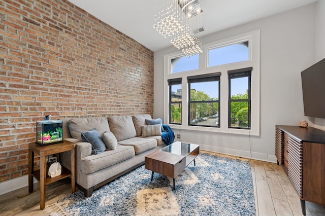 1423 N Ashland Ave Unit 201, Chicago, IL 60622 - living area featuring a chandelier, hardwood / wood-style flooring, brick wall, and baseboards