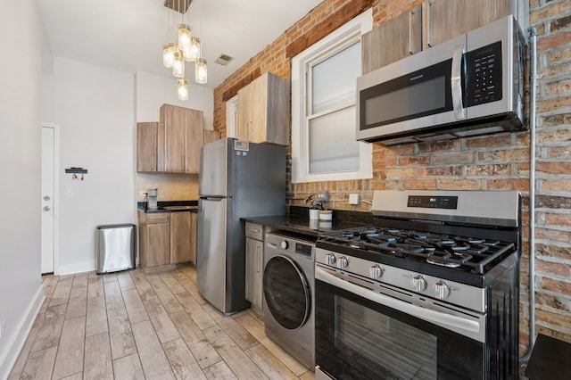 1423 N Ashland Ave Unit 201, Chicago, IL 60622 - kitchen with appliances with stainless steel finishes, washer / clothes dryer, dark countertops, tasteful backsplash, and light wood-style flooring