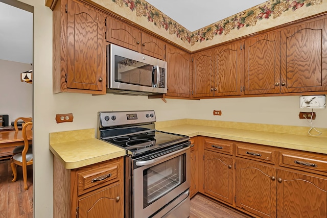 25408 W Willow Dr, Plainfield, IL 60544 - kitchen with stainless steel appliances, light wood-style floors, light countertops, and brown cabinetry