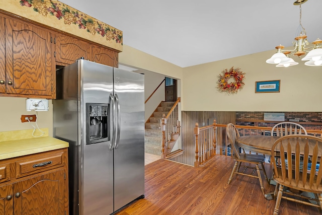 25408 W Willow Dr, Plainfield, IL 60544 - kitchen featuring stainless steel refrigerator with ice dispenser, wood finished floors, a chandelier, brown cabinets, and a wainscoted wall