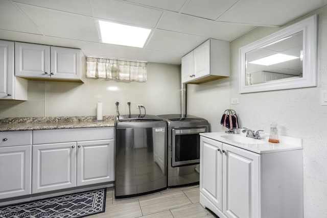 5036 Ozark Ave, Norridge, IL 60706 - kitchen featuring separate washer and dryer, a sink, white cabinets, a paneled ceiling, and light countertops