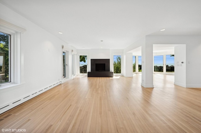 90 Kedzie St, Evanston, IL 60202 - unfurnished living room featuring a baseboard radiator, light wood-style floors, a fireplace with raised hearth, baseboards, and recessed lighting