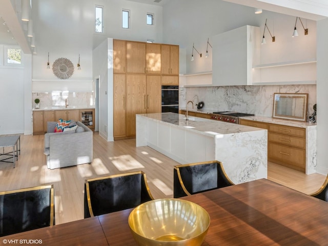 90 Kedzie St, Evanston, IL 60202 - dining space with a towering ceiling, light wood-style flooring, beverage cooler, healthy amount of natural light, and baseboards