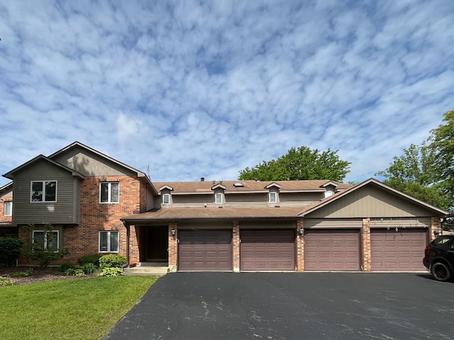 985 W Ct Unit D, Naperville, IL 60563 - view of front of property featuring brick siding, a front lawn, a garage, and asphalt driveway