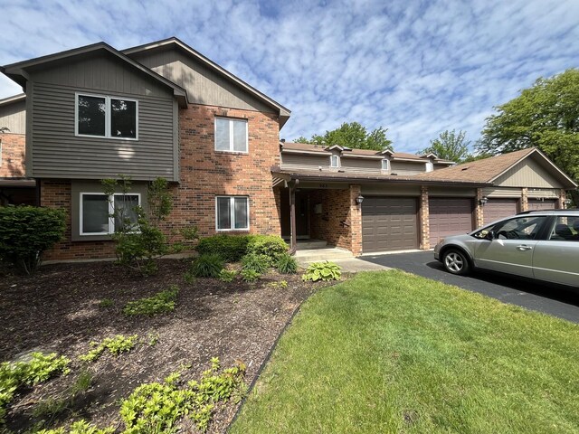 985 W Ct Unit D, Naperville, IL 60563 - view of front of house with a garage, brick siding, a front yard, and asphalt driveway