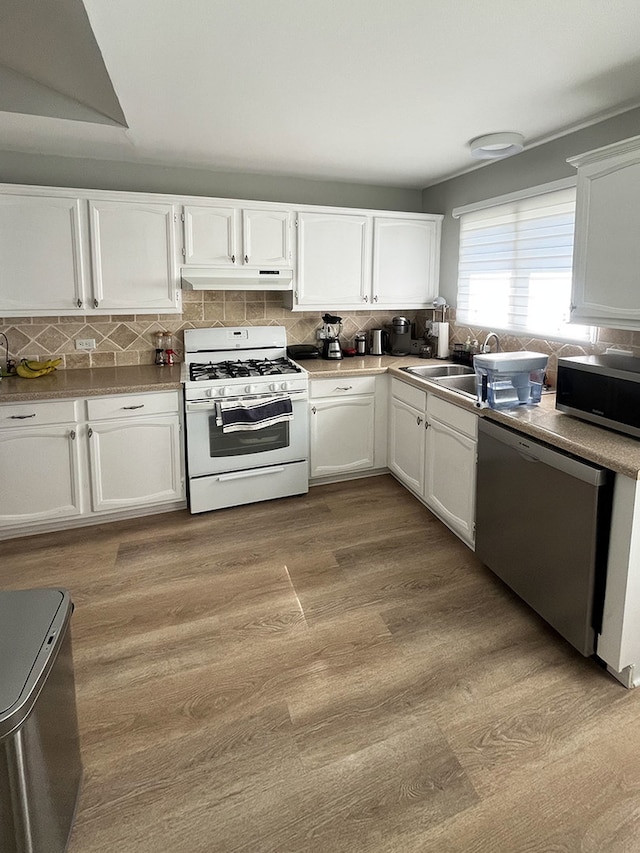985 W Ct Unit D, Naperville, IL 60563 - kitchen featuring appliances with stainless steel finishes, under cabinet range hood, white cabinetry, and backsplash